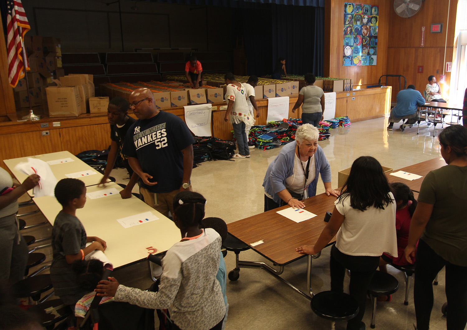 Board members Carole Mineo and Phil Howard help distribute backpacks.