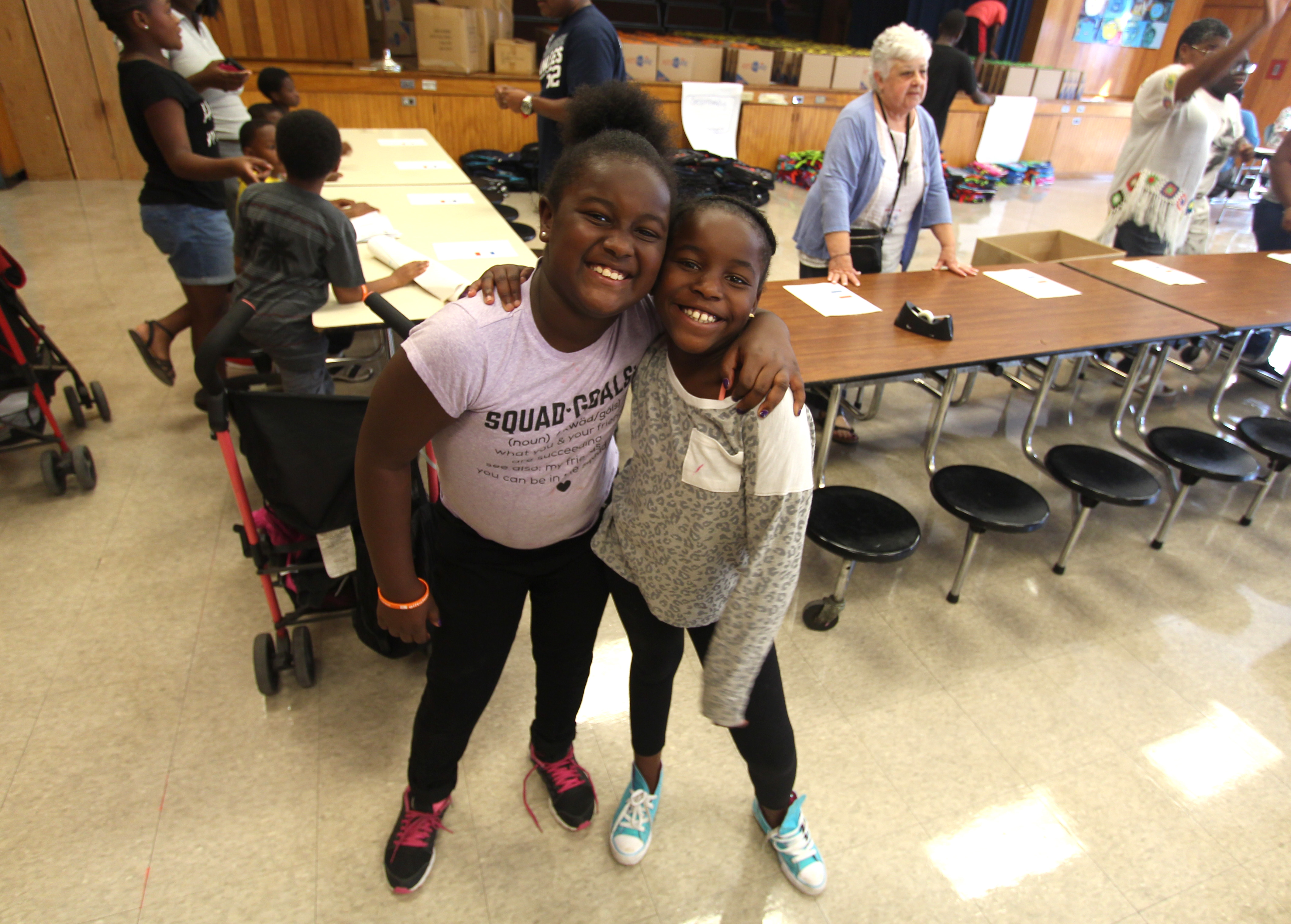 Two students are excited about their backpacks and schools supplies.