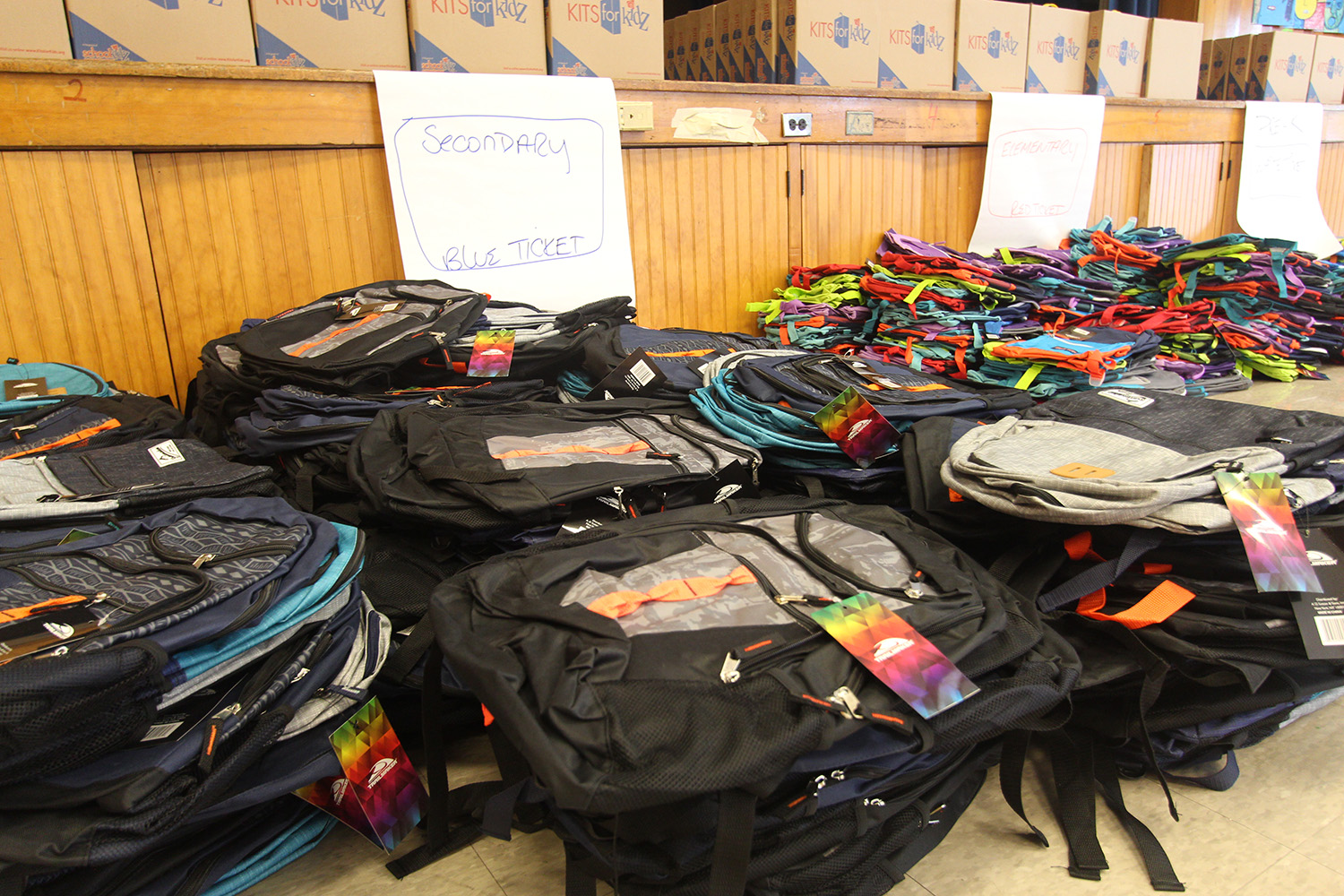 Backpacks are stacked up and ready to distribute.