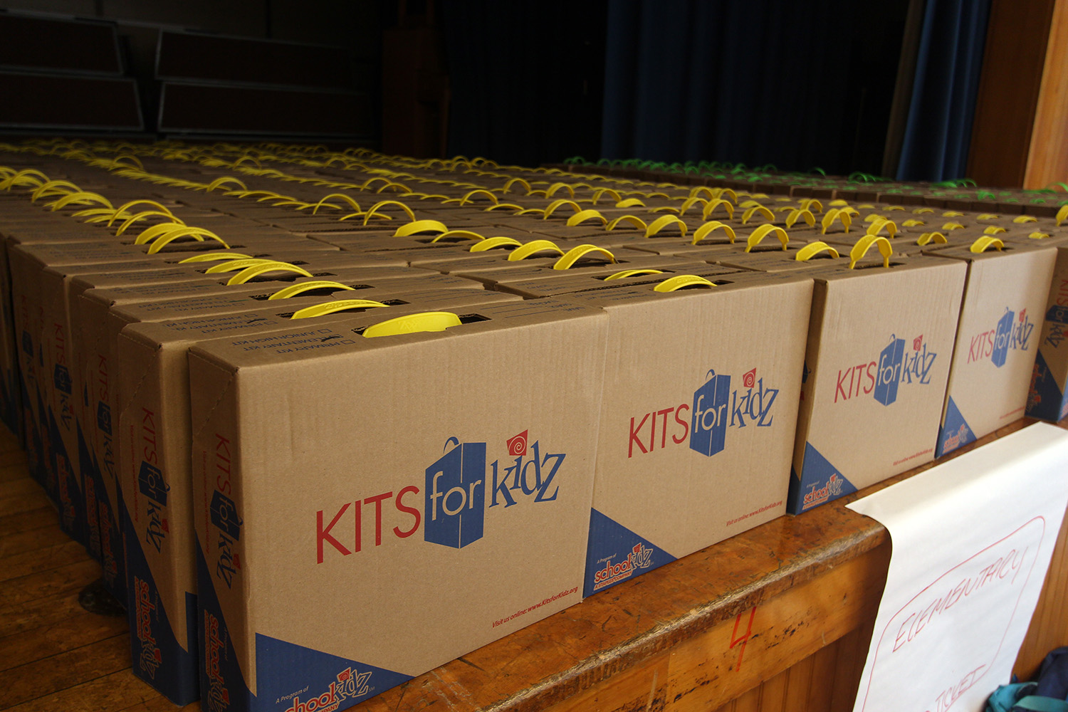 The boxes of school supplies are organized by grade level and ready to distribute.