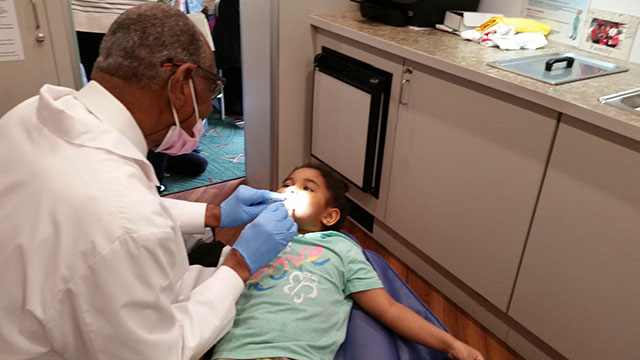 The dentist examining a student.
