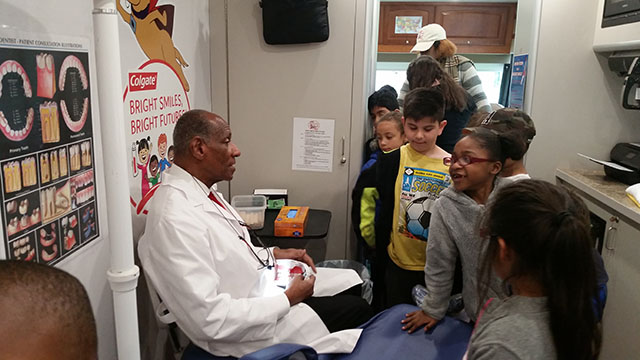 Dentist greets students.