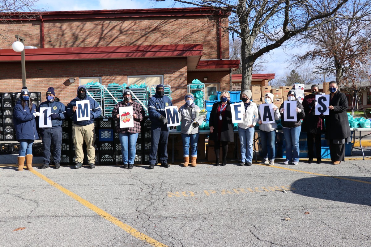 Vails Gate STEAM Academy Meal Distribution team celebrates 1 Million Meals with signs and a group photo.