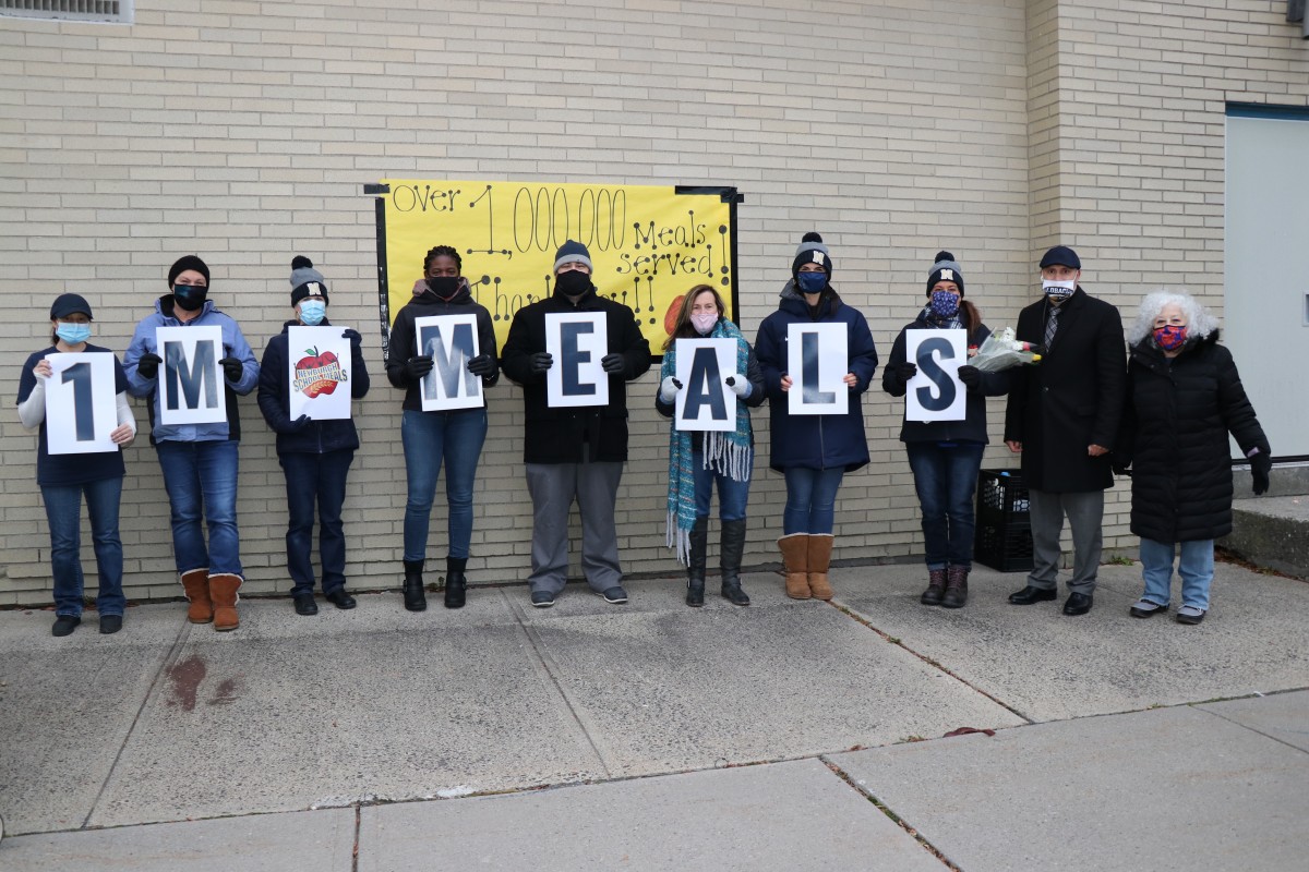 Meadow Hill School Meal Distribution team celebrates 1 Million Meals with signs and a group photo.