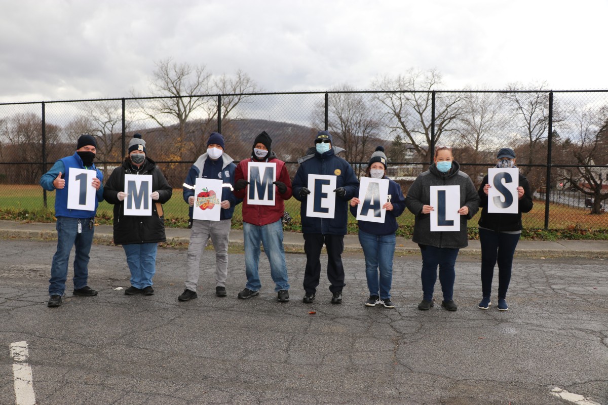 South Middle School Meal Distribution team celebrates 1 Million Meals with signs and a group photo.