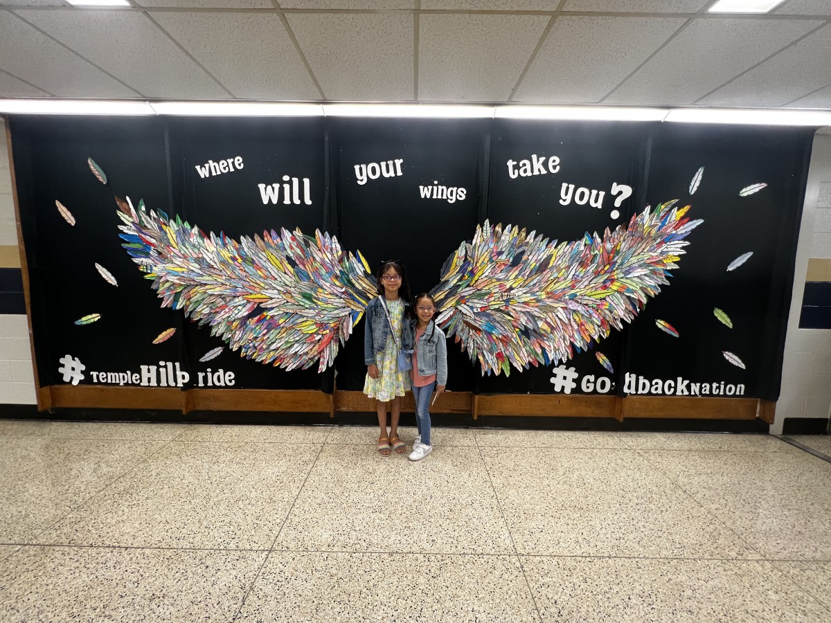 two students with Wings Mural