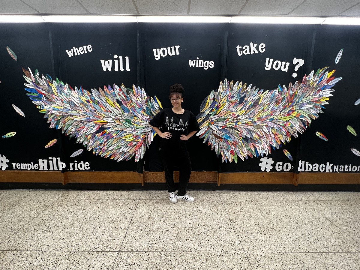 A student with Wings Mural