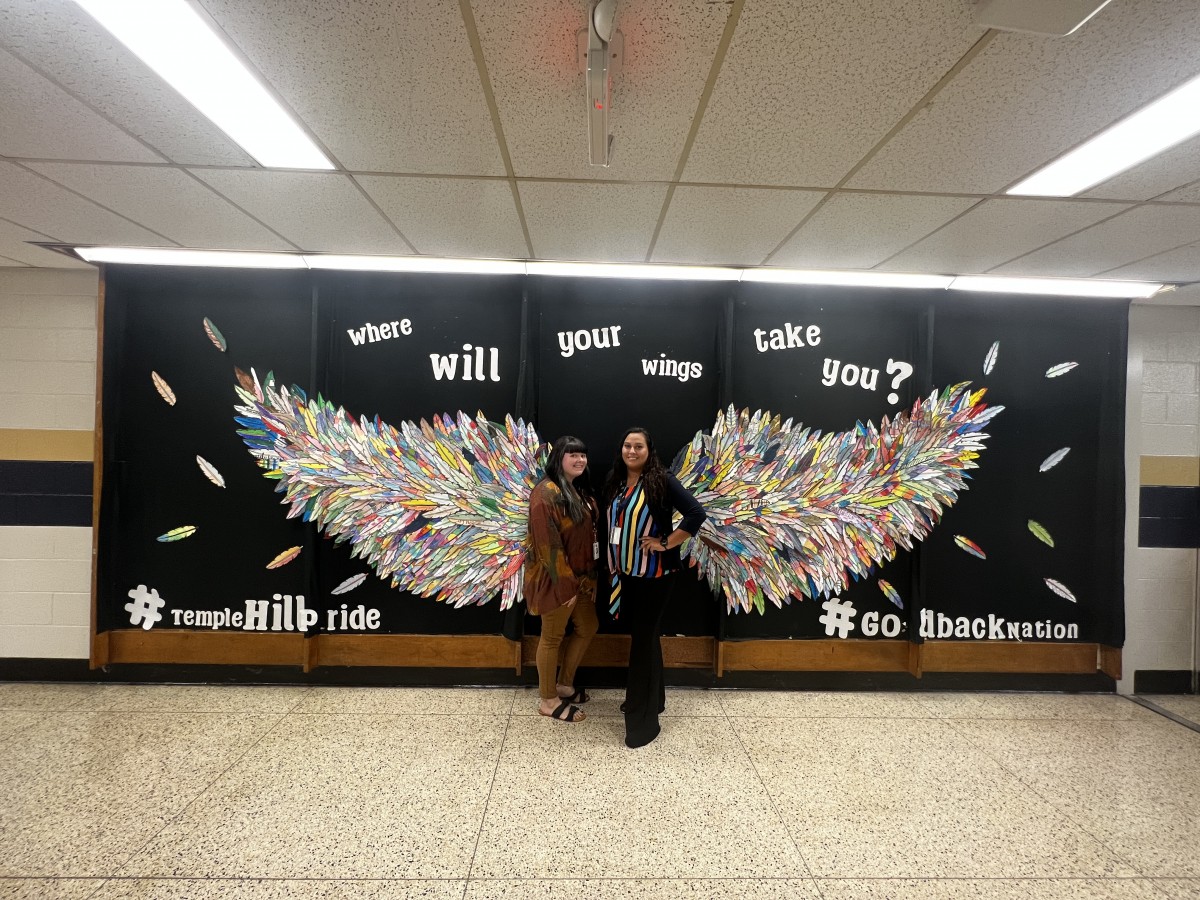 2 Temple hill staff members with Wings Mural
