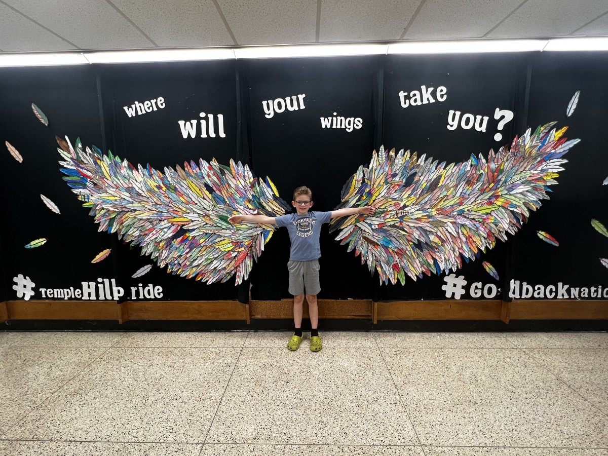 young student with Wings Mural