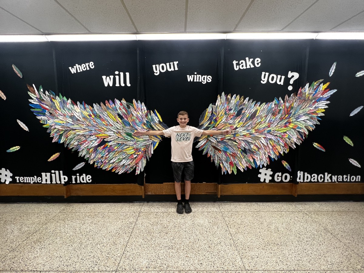 young student with Wings Mural