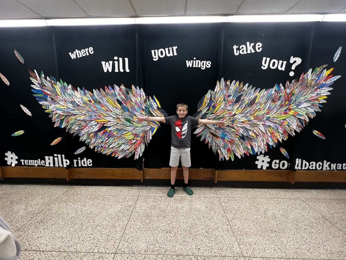 young student with Wings Mural