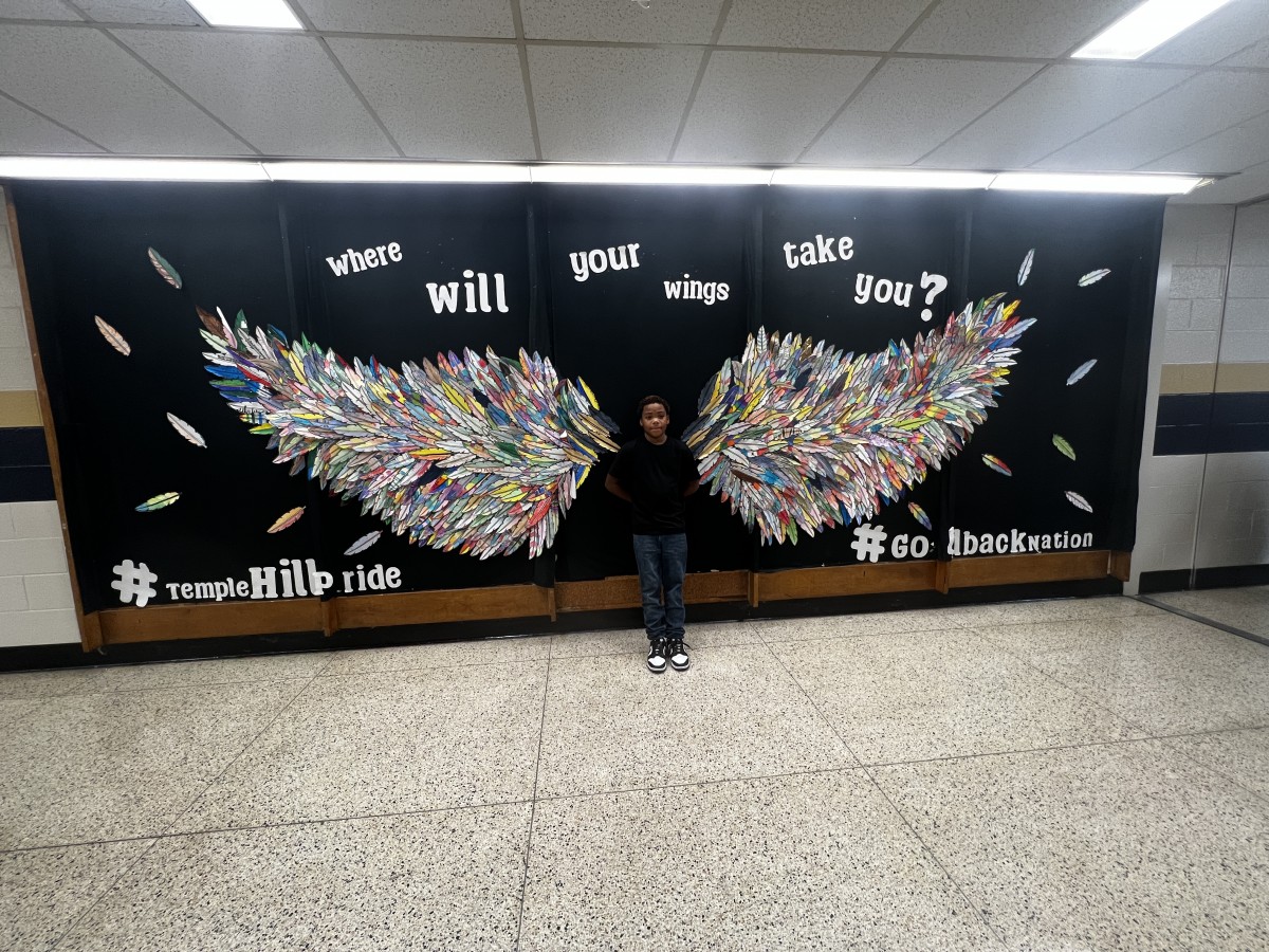 young student with Wings Mural