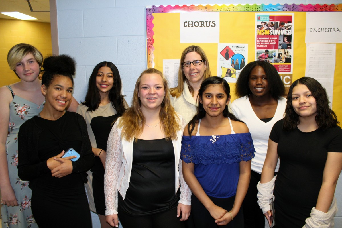 The 8th Grade Chorus Members. (From L to R) Front Row: Visella De la Cruz, Kamryn Betcher, Brianna Garcia, Arieth Valenzuela. (From L to R) Back Row: Sabrina Hope, Yosr Haggui, Ms. Clina, and Katayshia Rogers. Missing at the time of the photo Auriel Rosemberg.