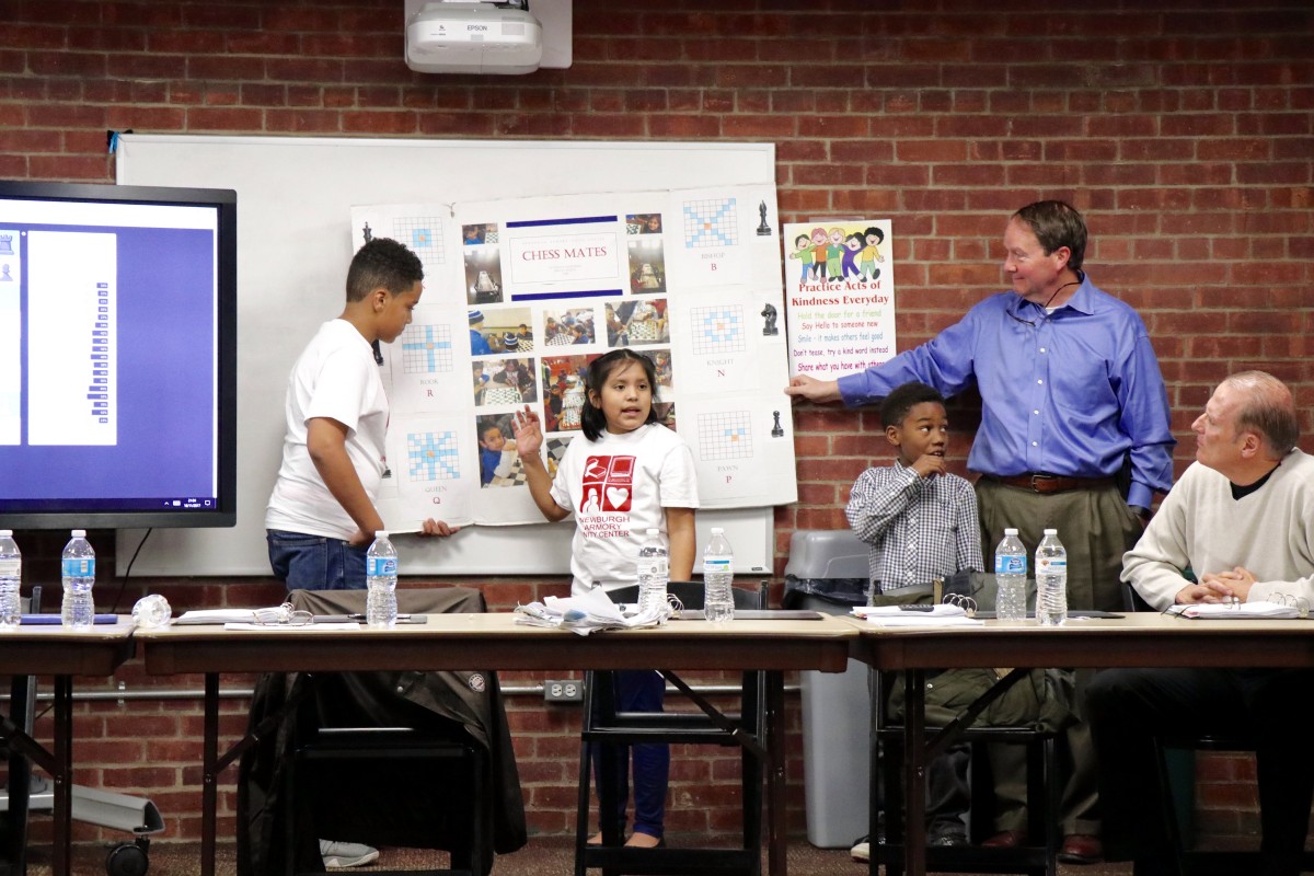 4th grade Isabella explains the game of chess to Armory Board members