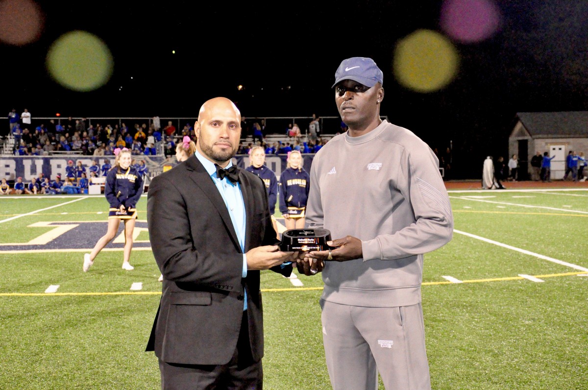 Coach Malcolm Burks honored as Boy’s Track and Field Coach of the Year at a football game. Pictured with Dr. Padilla, Superintendent of Schools