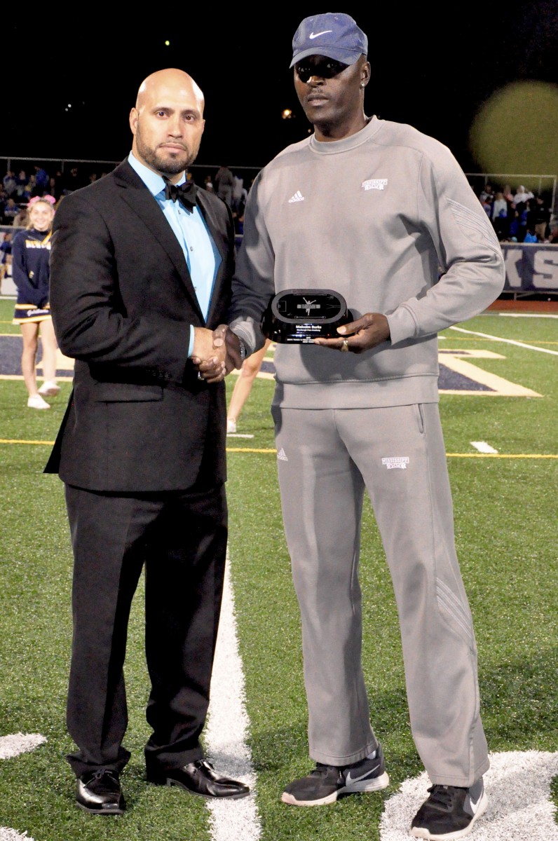 Coach Malcolm Burks honored as Boy’s Track and Field Coach of the Year at a football game. Pictured with Dr. Padilla, Superintendent of Schools