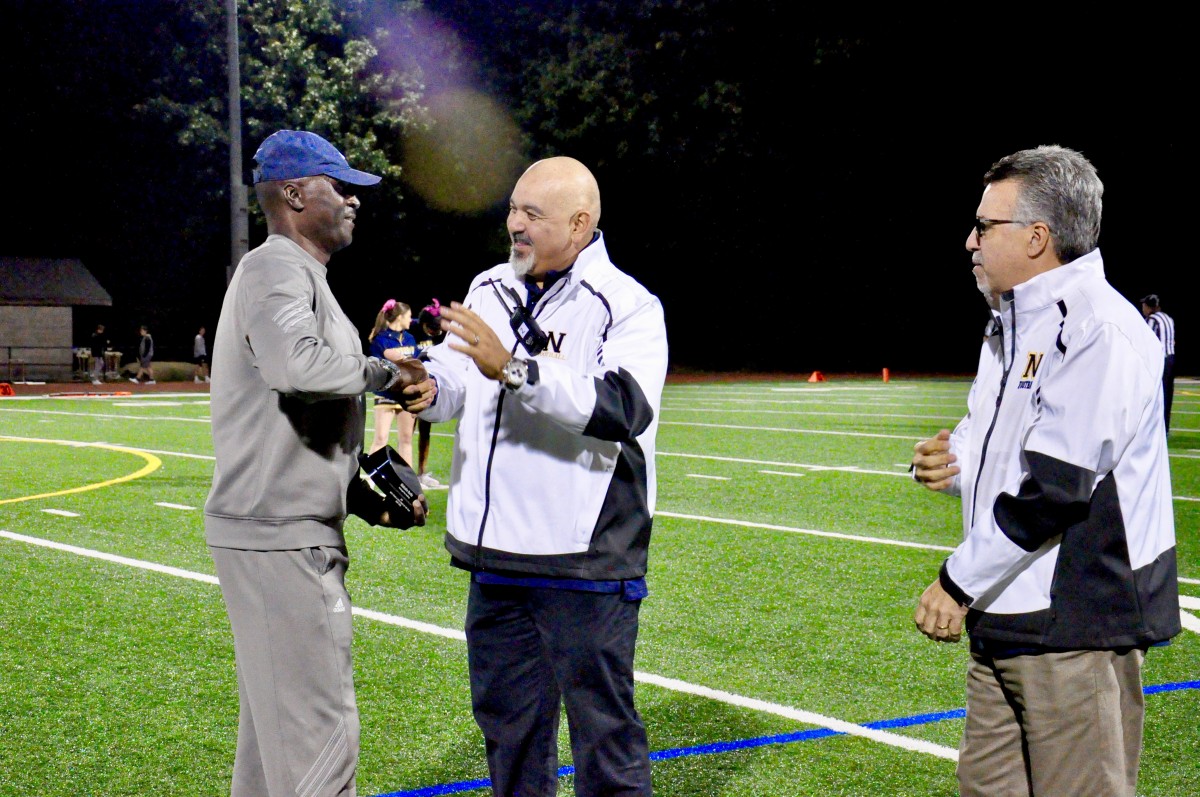 Coach Malcolm Burks honored as Boy’s Track and Field Coach of the Year at a football game. Pictured with Principals Rodriguez and Doddo.