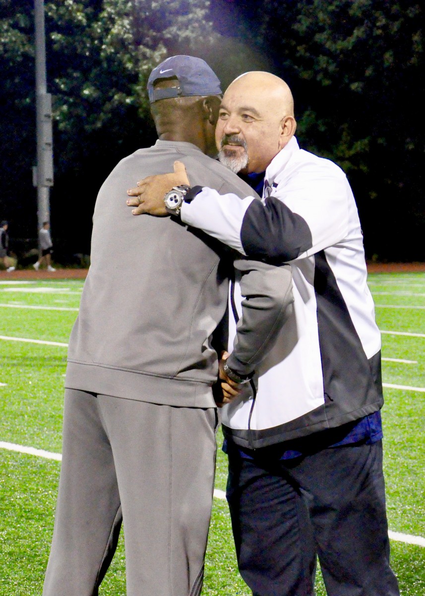 Coach Malcolm Burks honored as Boy’s Track and Field Coach of the Year at a football game. Pictured with Principal Rodriguez.