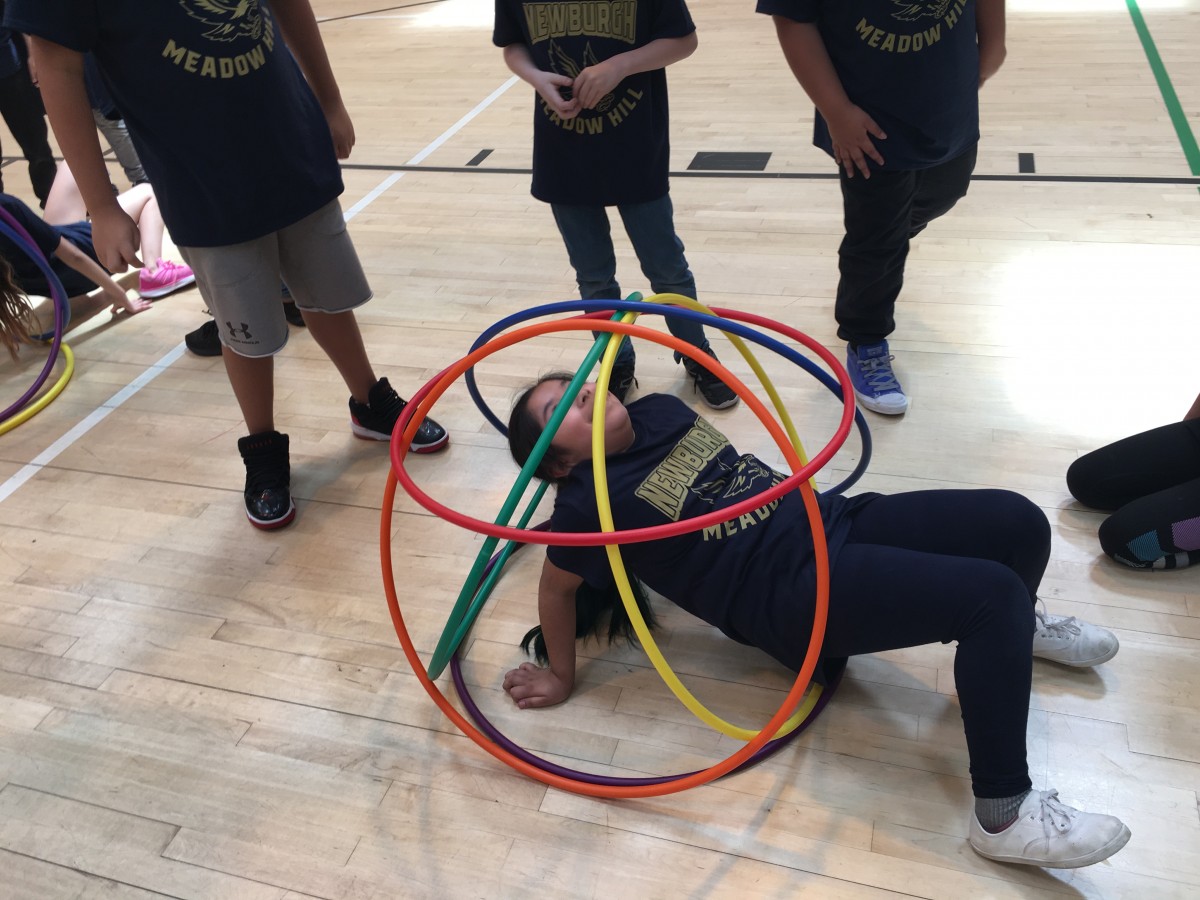 Students participate in activity with hoops.