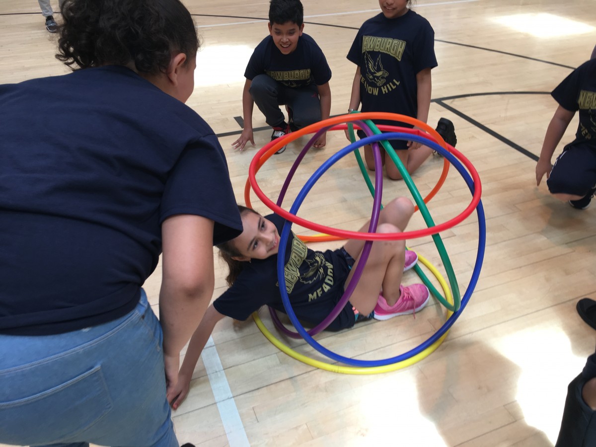 Students participate in activity with hoops.