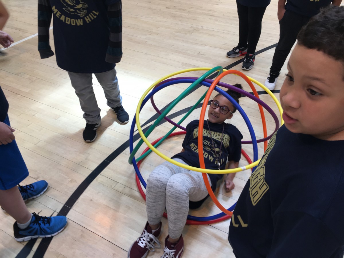 Students participate in activity with hoops.