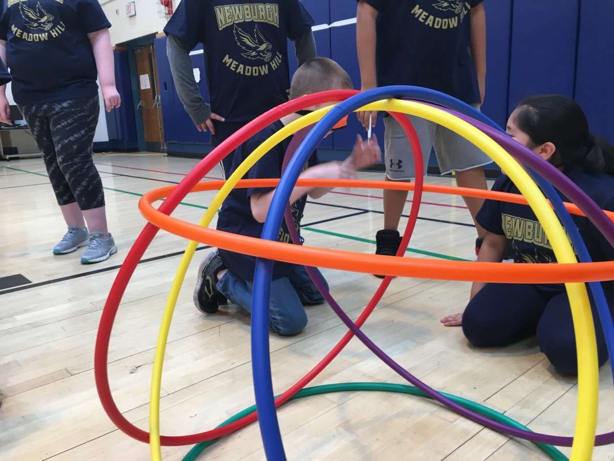 Students participate in activity with hoops.