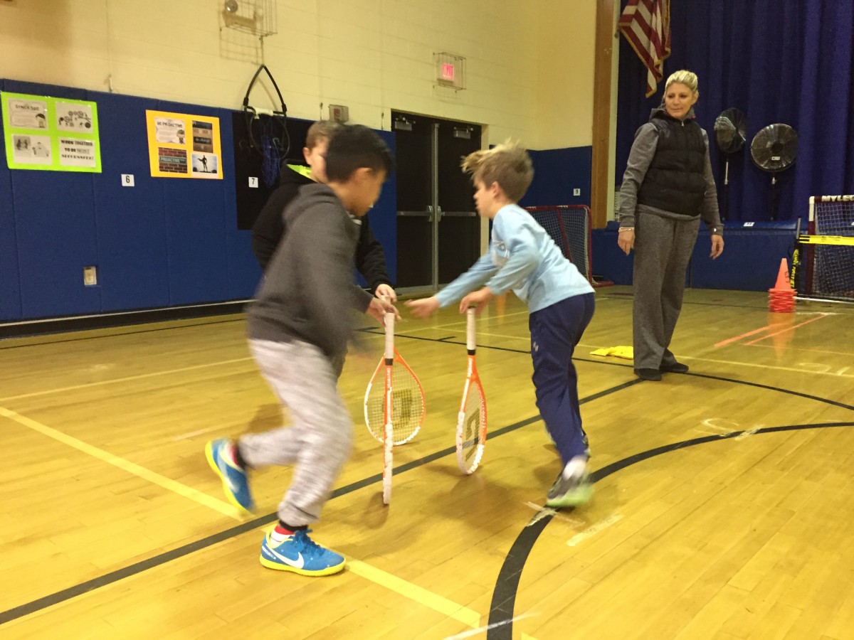 Students practice tennis skills as part of the program.