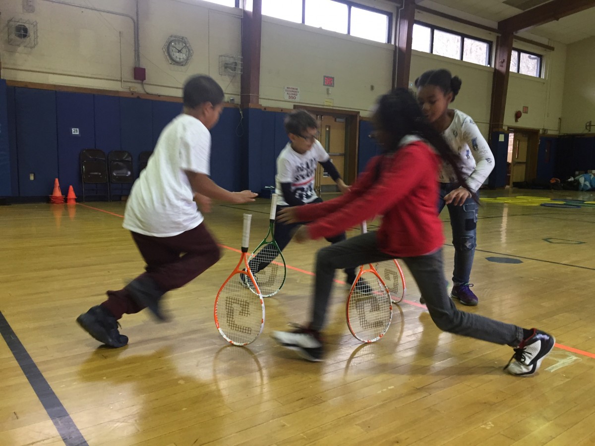 Students practice tennis skills as part of the program.