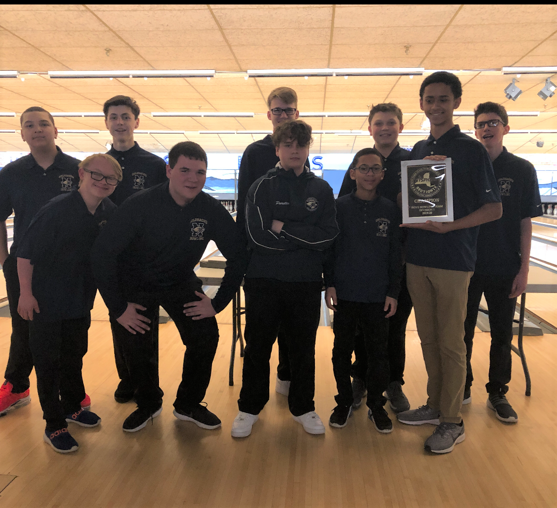 The NFA Boys Varsity Bowling Team poses for a photo with their plaque.