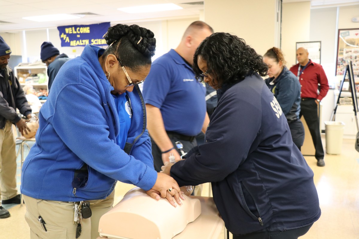 Security guards practicing proper form for basic life Basic Life Support (BLS) CPR.