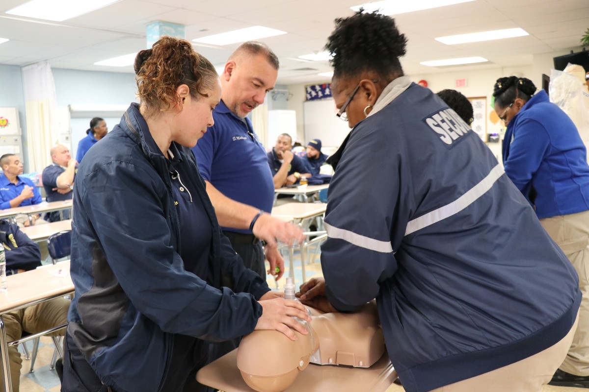 Security guards practicing proper form for basic life Basic Life Support (BLS) CPR.