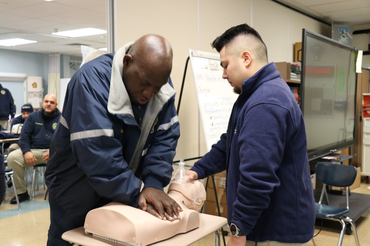 Security guards practicing proper form for basic life Basic Life Support (BLS) CPR.