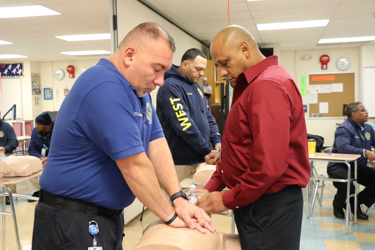 Security guards practicing proper form for basic life Basic Life Support (BLS) CPR.