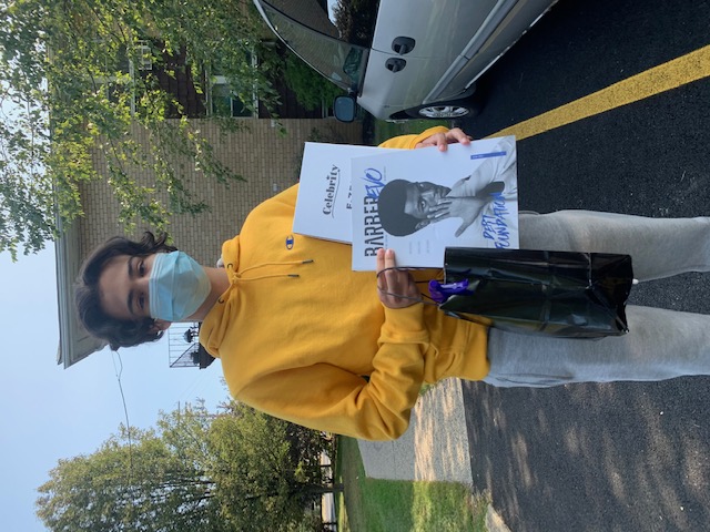 Student poses with a picture holding their supplies.