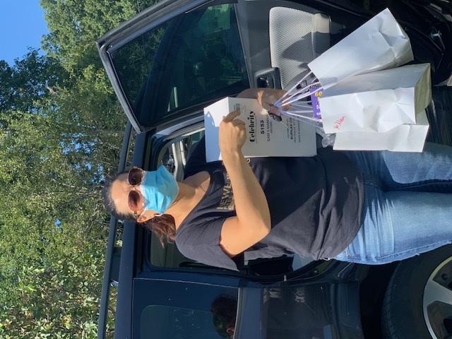 Student poses with a picture holding their supplies.