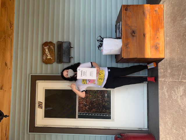 Student poses with a picture holding their supplies.