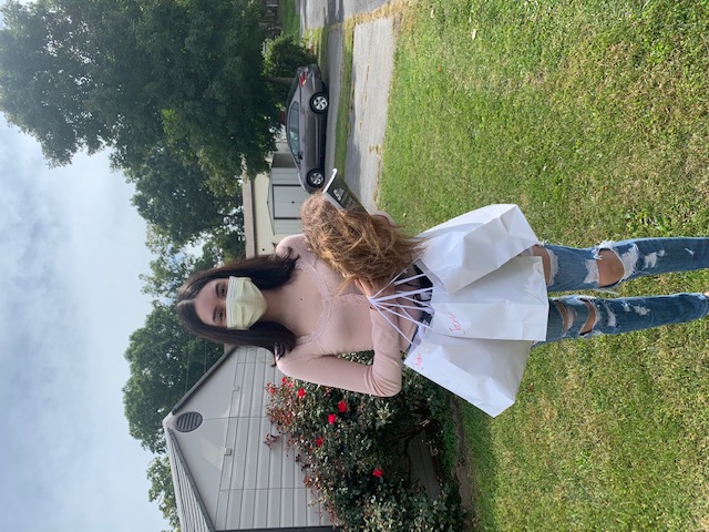 Student poses with a picture holding their supplies.