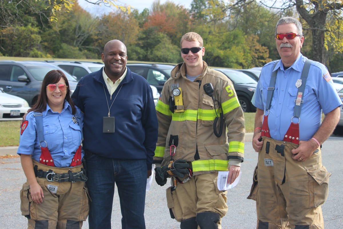 Firefighters pose with assistant principal Mr. Armand.