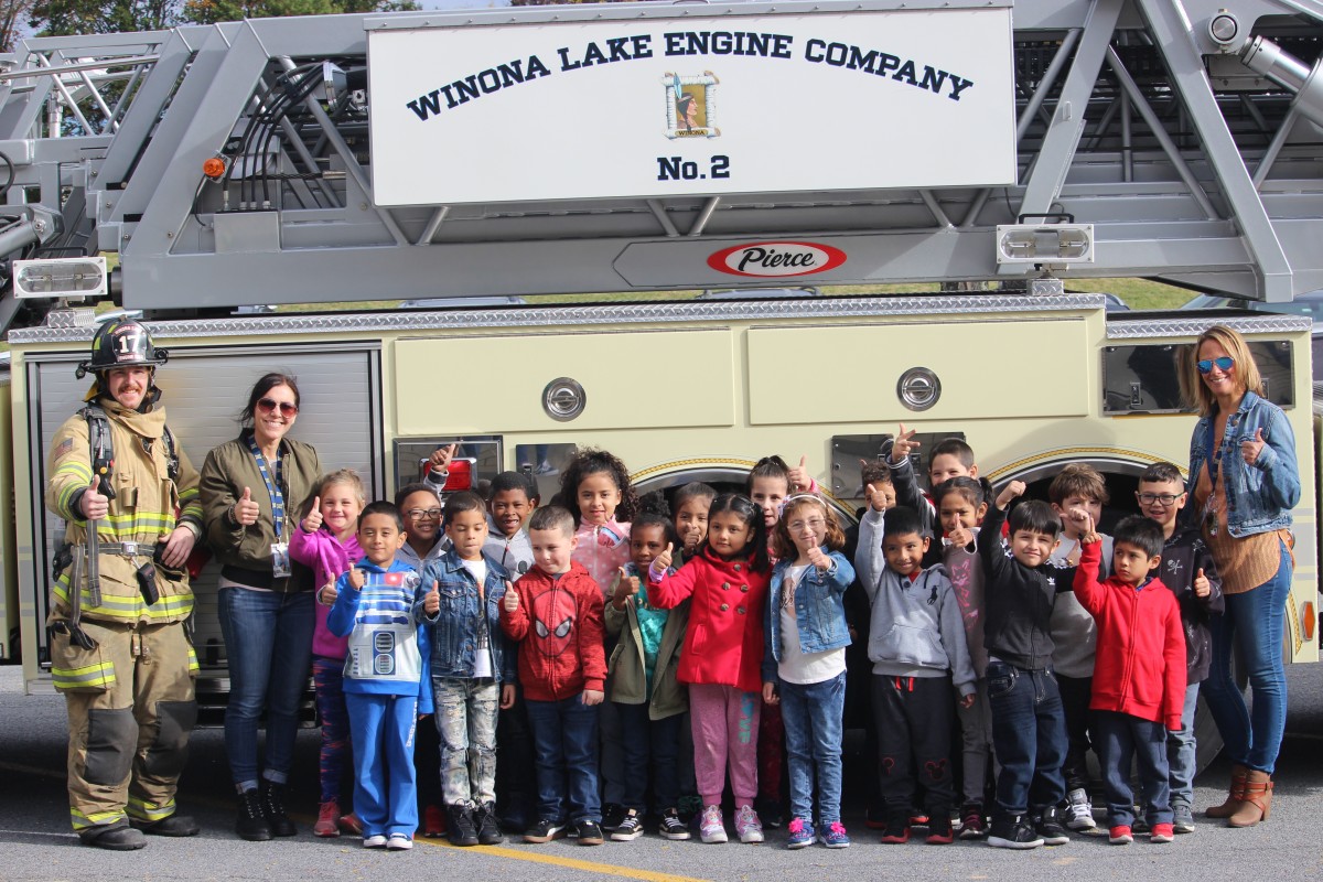 Students pose in front of a truck.