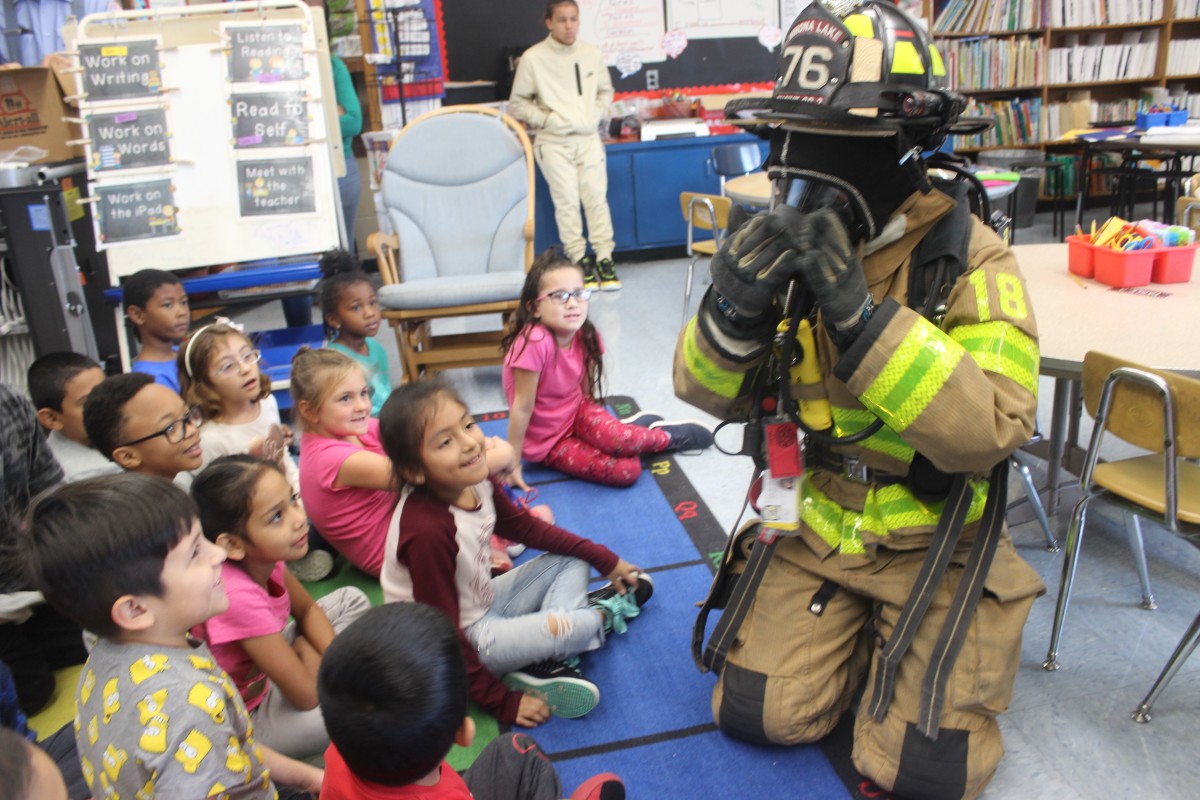 Students learn from a firefighter.