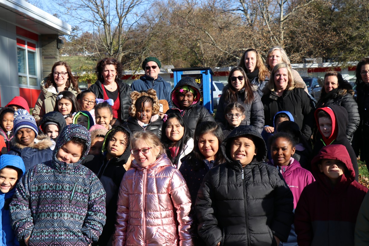 Group of attendees around the lending library.