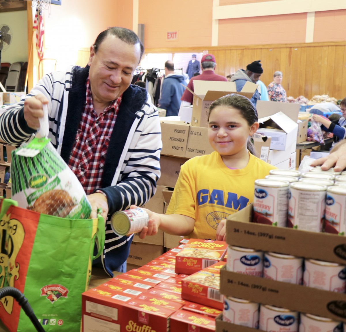 Student distributes food with Assemblyman Skartados