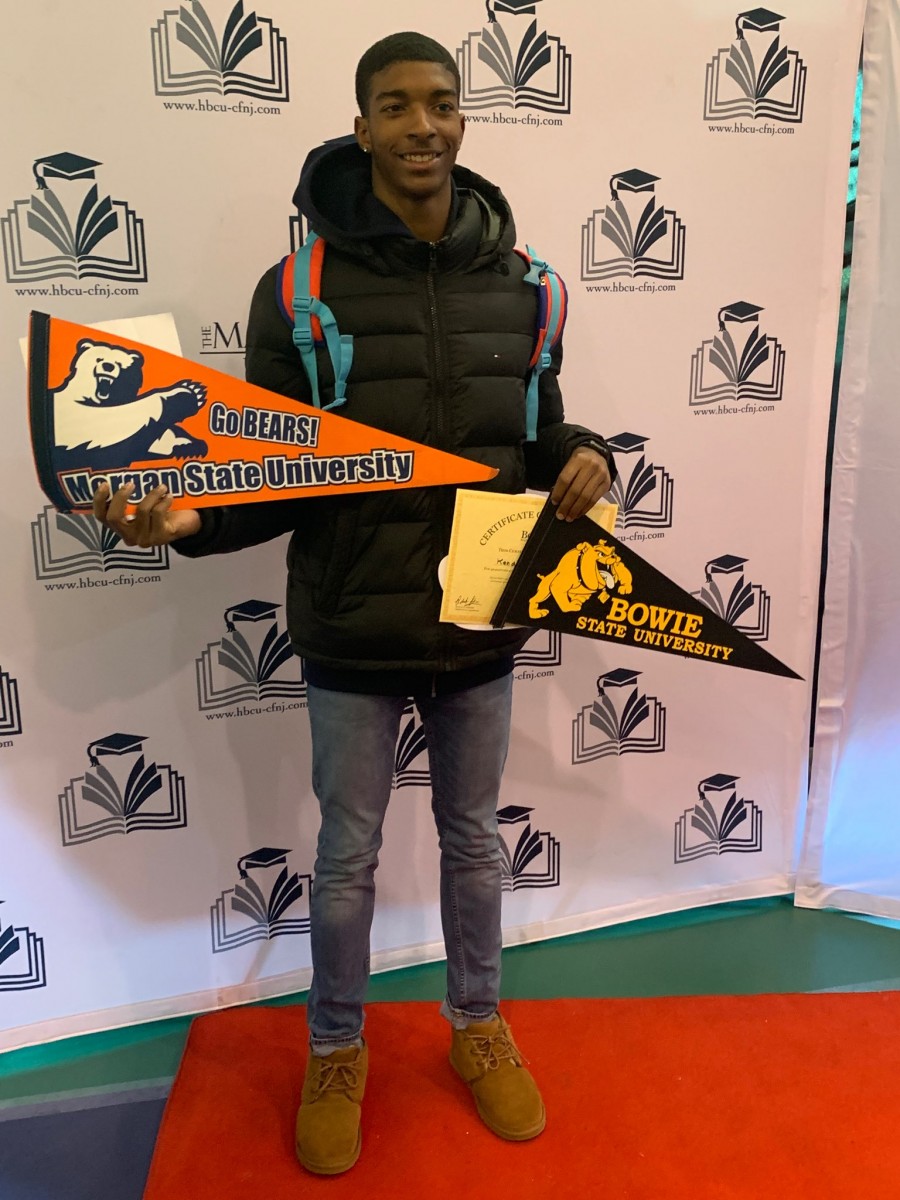 Student poses with college pennants.