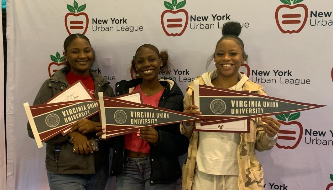 Students pose with college pennants.