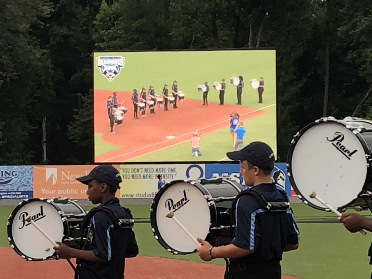 Drumline performs near field and can be seen on the jumbotron.