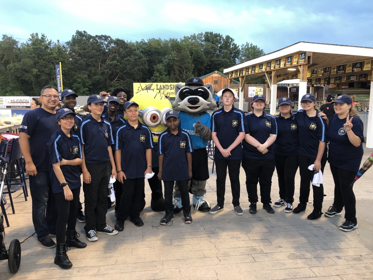 Group stands with mascot.