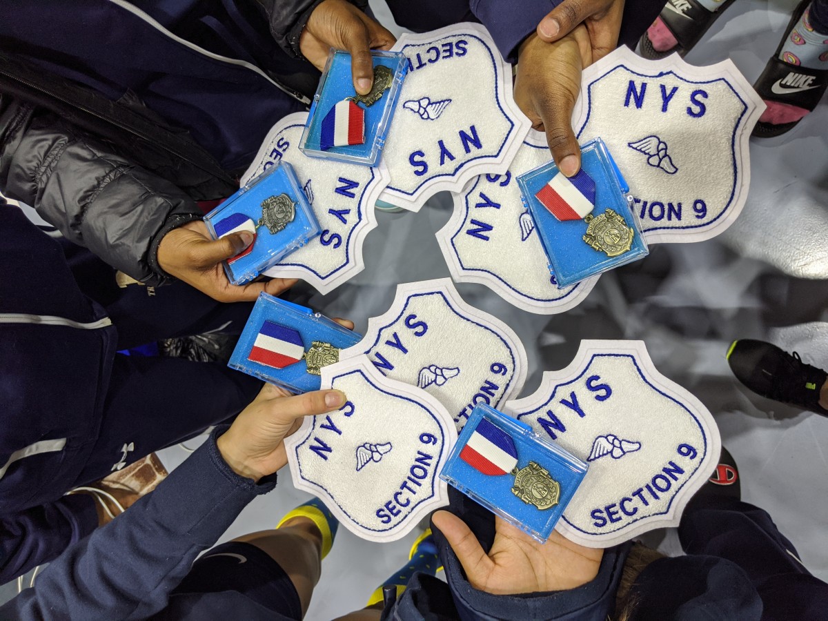 Athletes hold their medals and patches.