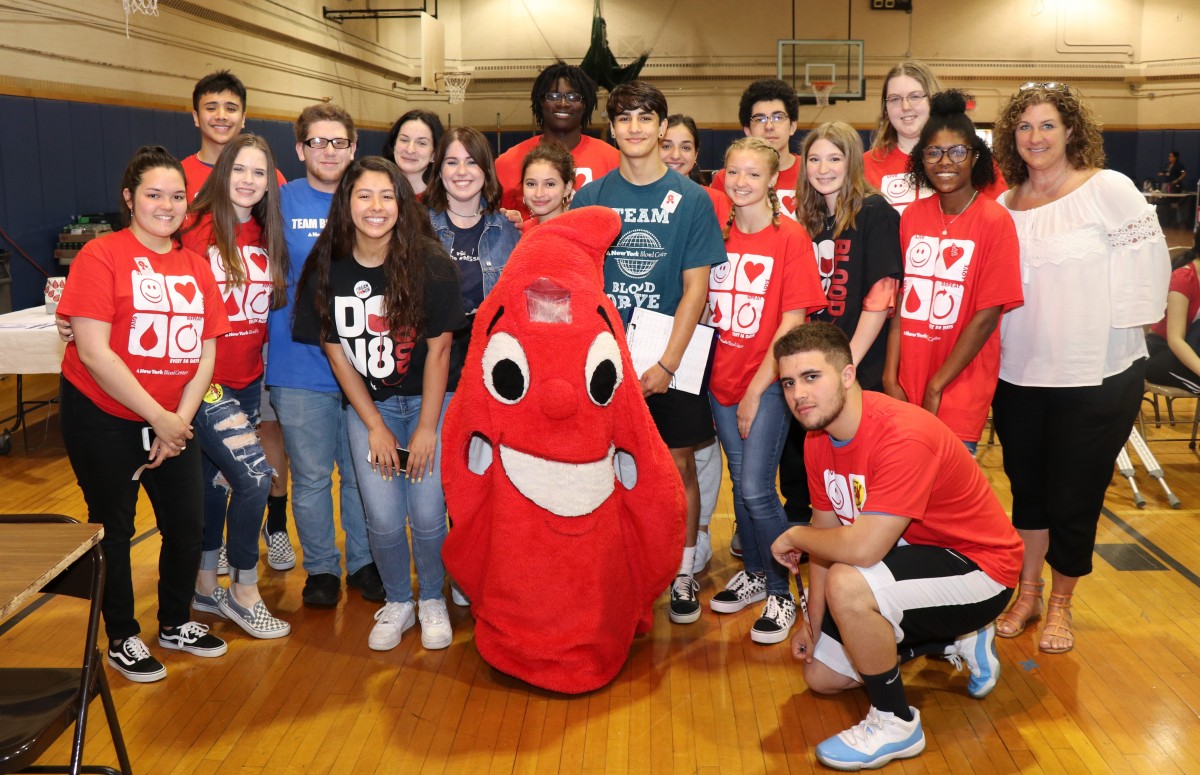 Student volunteers pose with blood drop mascot.