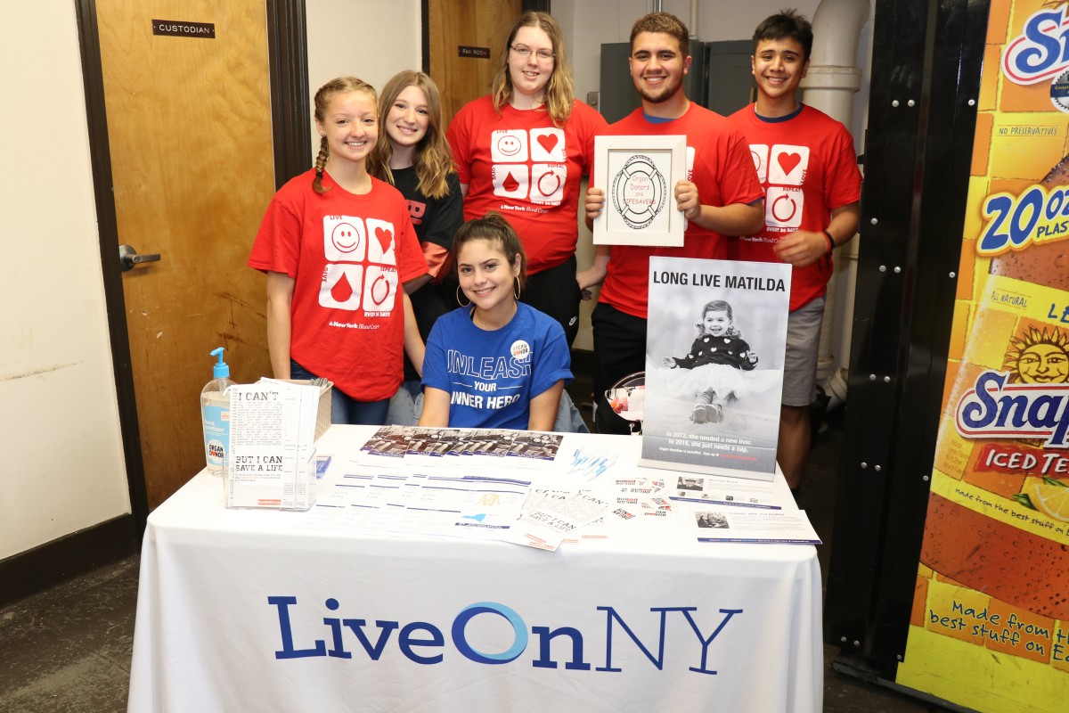 Students pose at organ donor table.