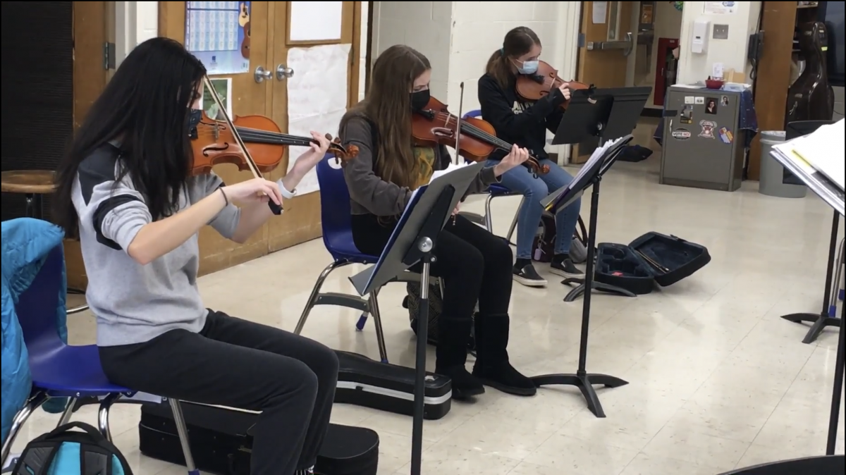 Students playing their string instruments.